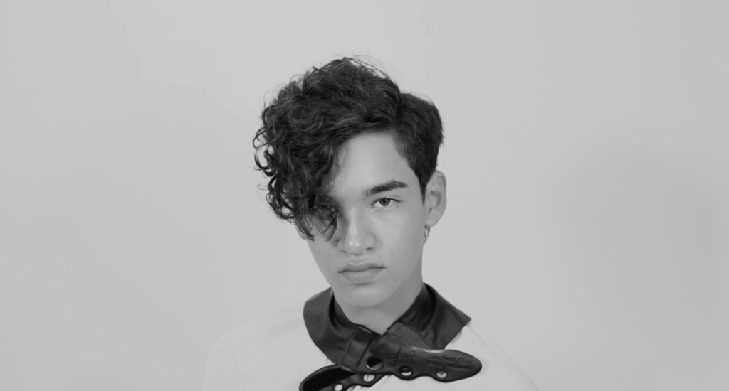 Foto en blanco y negro de un joven con un corte de cabello en silueta.